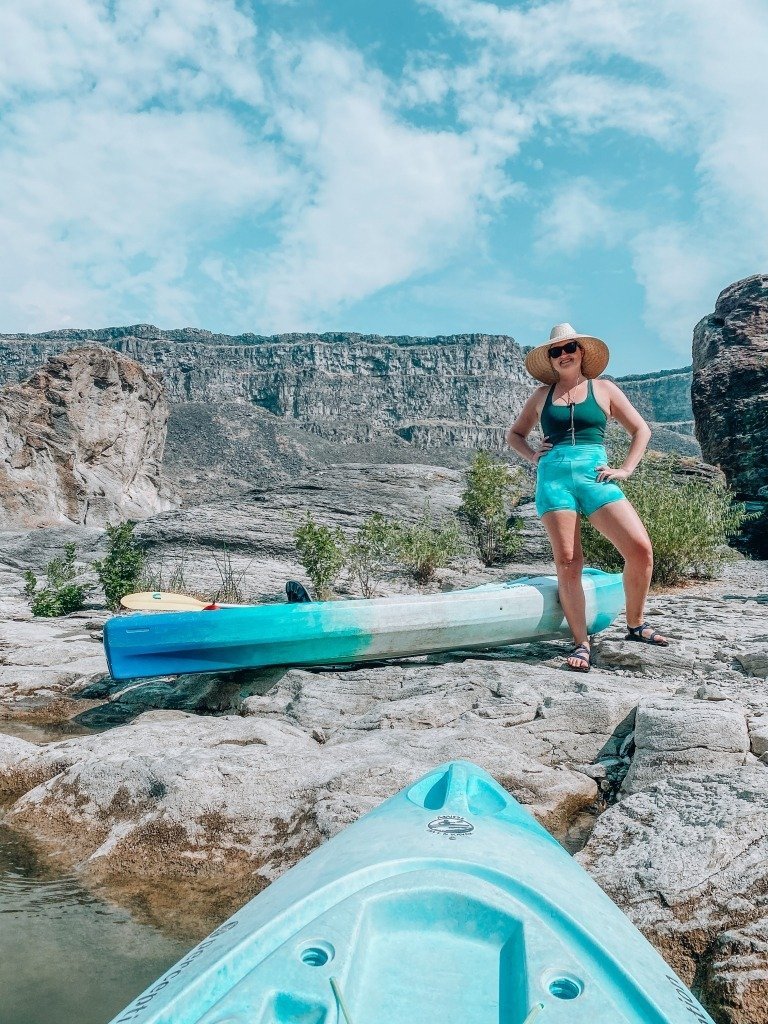 woman posing beside kayak