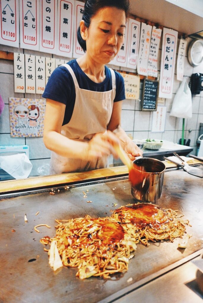 Japanese woman making okonomiyaki